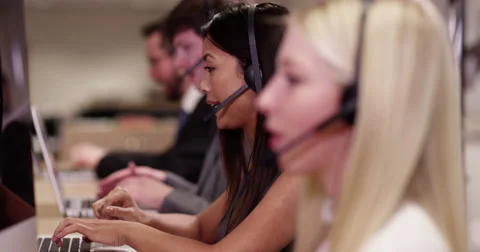 4k, A team of call centre executives wearing headset busy on a phone Stock Footage 61552737