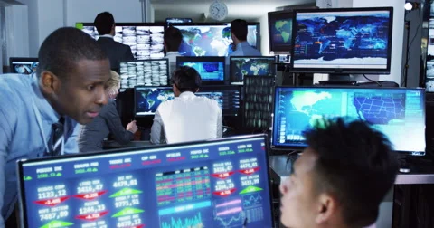 4K Team of financial brokers watching the world markets in a busy trading room Stock Footage