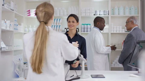 4K Team of staff working & serving customers in a chemist shop Stock Footage
