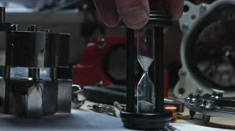 4k technical composition of a human hand placing the sand clock Stock-Footage 64765392