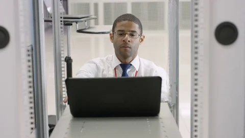 4K Technical engineer carrying out checks in a data center server room Stock Footage