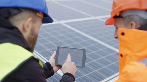 4K Technicians with tablet checking the panels at solar energy installation Stock Footage 70016585