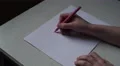 4K teenage girl is writing OMG! You're gorgeous on white paper on wooden table 4k or 4k+ Resolution