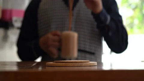4K Teh Tarik Malaysian Pulled Tea, poured into a glass and place on the table fo Stock Footage 195406111