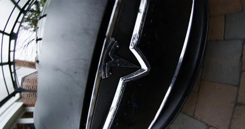 4k Tesla Model S close up logo spin out to front of car in driveway Stock Footage 137618332