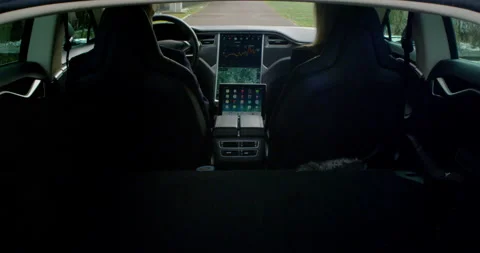 4k Tesla Model S Driver and passanger parked watching iPad sitting in car Stock Footage 137612536
