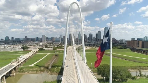 4K Texas Flag Blows in Breeze Dallas Skyline Margaret Hunt Hill Bridge Stock Footage 95824734