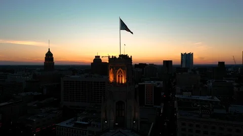 4K Texas Flag Fly By Over San Antonio Texas at Sunset San Antonio Skyline Stock Footage 119736776