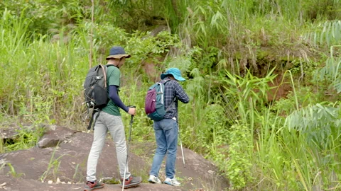 4K, These two Asian men, and women, carrying their bags and wearing their Stock Footage 203845097
