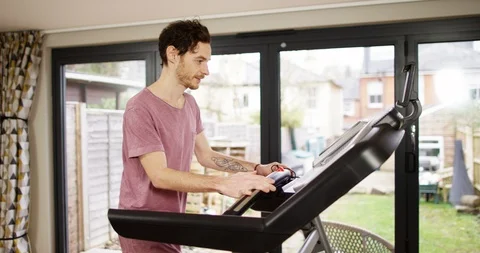 4K Thin athletic man walking on treadmill in home gym Stock Footage 88607811