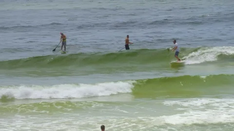 4K Three Mean Riding Paddle Boards in the Ocean Video stock 111031475