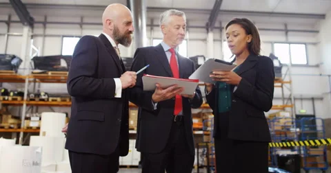 4k, Three warehouse workers discussing logistics of their business in warehouse Stock Footage 68958731