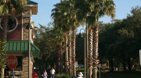 4K Tilt Down Shot of Couple Crossing Street in Orlando Florida Tourist Area Vídeo Stock 63619435