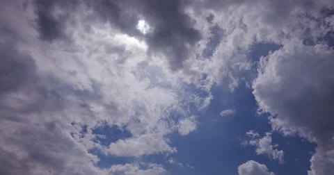 4K Time-lapse of clouds moving in front of the sun Stock-Footage 64694646