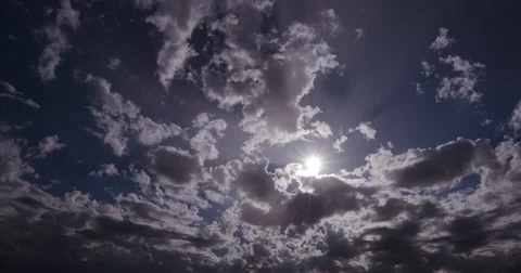 4K Time-lapse of clouds moving in front of the sun Stock Footage 64694679