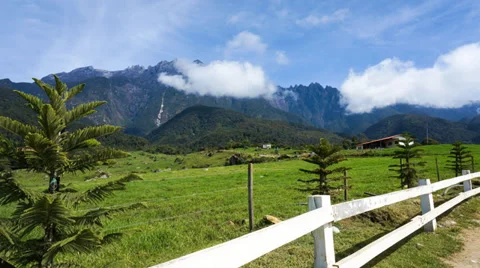4K. Time lapse of clouds over the green field and Mount Kinabalu. FULL HD Stock Footage 36723098
