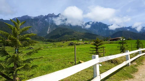 4K. Time lapse of clouds over the green field and Mount Kinabalu. FULL HD 스톡 동영상 36723236