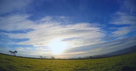 4K time lapse clouds over a green field early morning sunshine Stock Footage 82793045