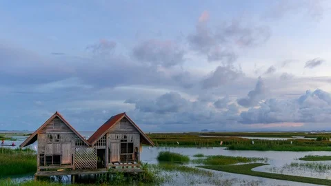 4K Time lapse of cloudy sunset over abandoned house at lake Thale Noi. Zoom In Stock Footage 96339919