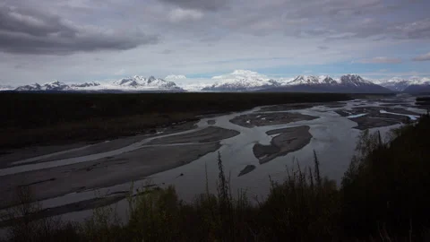 4K time lapse of dark clouds approaching a distant snowy Mount Denali in Alaska Stock Footage 242808903