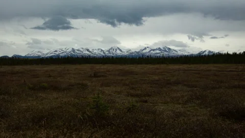 4K time lapse of dark storm clouds over snowy mountains and wetlands in Alaska Stock Footage 242538083