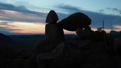 4K Time lapse of dawn clouds in blue sky silhouetting Balanced Rock in Big Bend Stock Footage 166541882