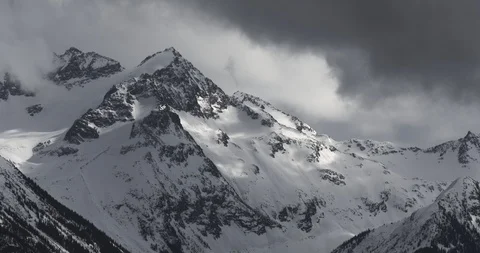 4K Time Lapse of Dramatic Snow Covered Alpine Peak Surrounded by Storm Clouds Video stock 106096418