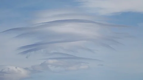 4K time lapse of fast moving, wavy, lenticular clouds in blue sky on a windy day Stock Footage 126439845