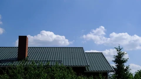 4K Time lapse of fast moving clouds on sky above the roof. Tranquil scenery of Stock Footage 130910206