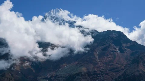 4K Time lapse footage of clouds moving rapidly with background of high peak Stock Footage 129406658