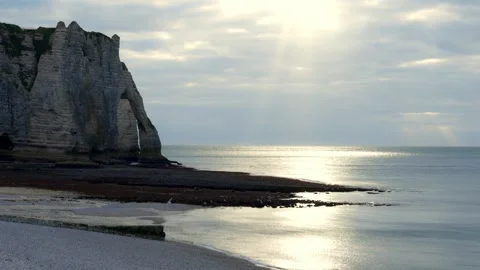 4K time-lapse footage of sun rays breaking through clouds over a calm sea. In Stock Footage 308372693