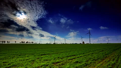 4k time lapse: Green spring field and wind turbines under blue sky. Stock Footage 154417764