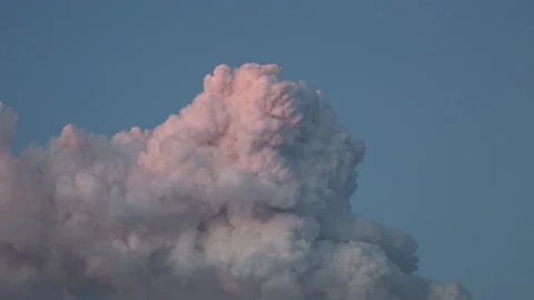 4K time lapse long shot of a pink pyrocumulus cloud billowing up at dusk 스톡 동영상 137469019