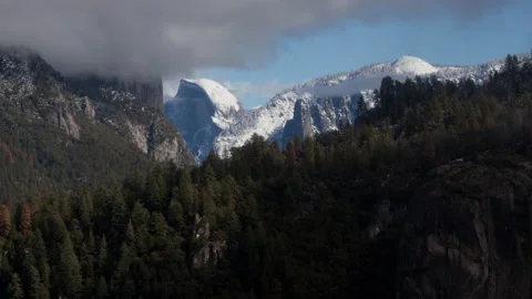 4K Time lapse long shot of snow covered Half Dome on a partly cloudy winter day Stock Footage 145487453