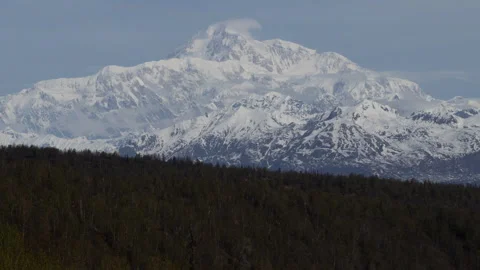 4K time lapse long shot of wispy spring clouds on a snowy Mount Denali in Alaska Stock Footage 242993748