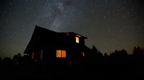4K time lapse of Milky Way galaxy stars above a rural home at night in Idaho Stock Footage