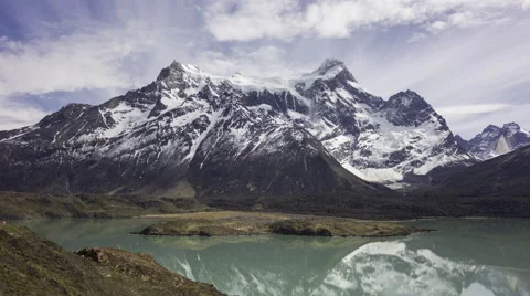 4K time lapse moving clouds above a mountain reflecting in a turquoise lake Video stock 57335697