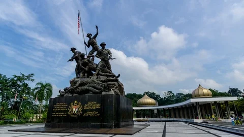 4K time lapse of moving clouds over National Monument  in Kuala Lumpur. Zoon In Stock Footage 97510663