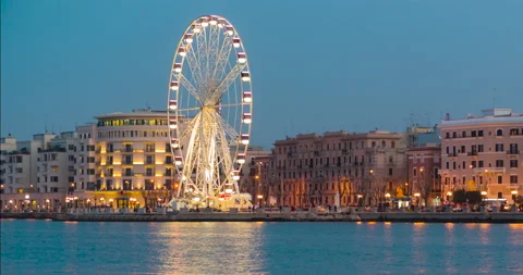 4K time lapse panoramic Night view of Illuminated giant Ferris wheel on the w Vídeo Stock 136856488
