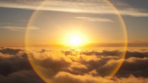 4K Time lapse of a solar lens flare of the setting sun above inversion clouds Stock Footage