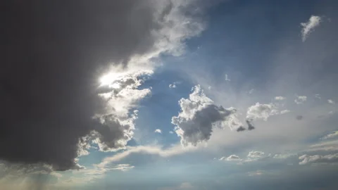 4K time lapse of the sun obscured by approaching, big, dark clouds in a blue sky Video stock 217589218