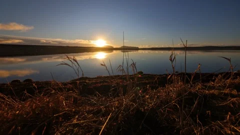 4K time lapse of the sun setting behind the Hoy hills reflecting on water Video stock 297285261