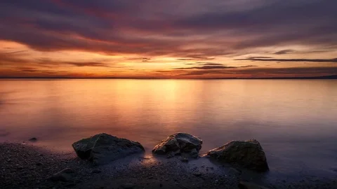 4K Time Lapse Sunset Lake Rocks Beach Clouds Dolly Stock Footage 71383296