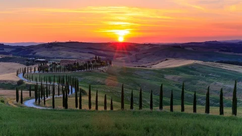 4K Time lapse Sunset over the rolling hills and winding road in Tuscany, Italy Stock Footage