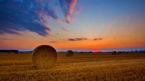 4k time lapse with sunset over field with round straw bales. Stock Footage 154508834