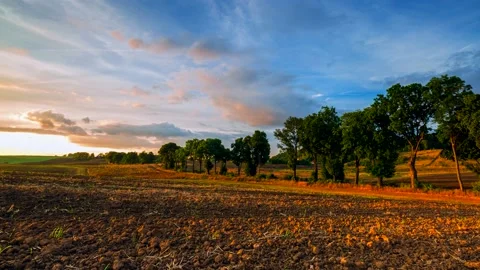 4k time lapse with sunset sky over plowed field and country side. Stock Footage 154434048