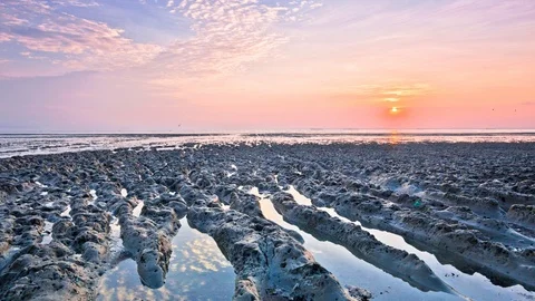 4K Time Lapse view of sunrise with mud texture as foreground Stock Footage 103987126
