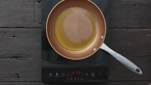 4k Time lapse of woman's hands, preparing and heating up oil in a pan on inducti Stock Footage 199615973