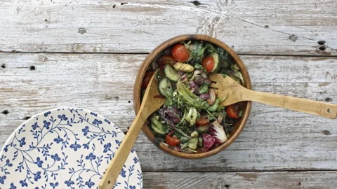 4k Time lapse of woman's hands tossing, and dishing salad,  ready to eat. 動画素材 199616342