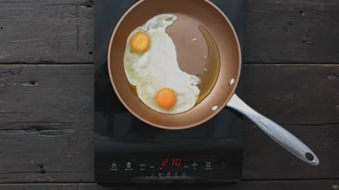 4k Time lapse of woman's hands frying eggs on digital induction stove. Stock Footage 199616479